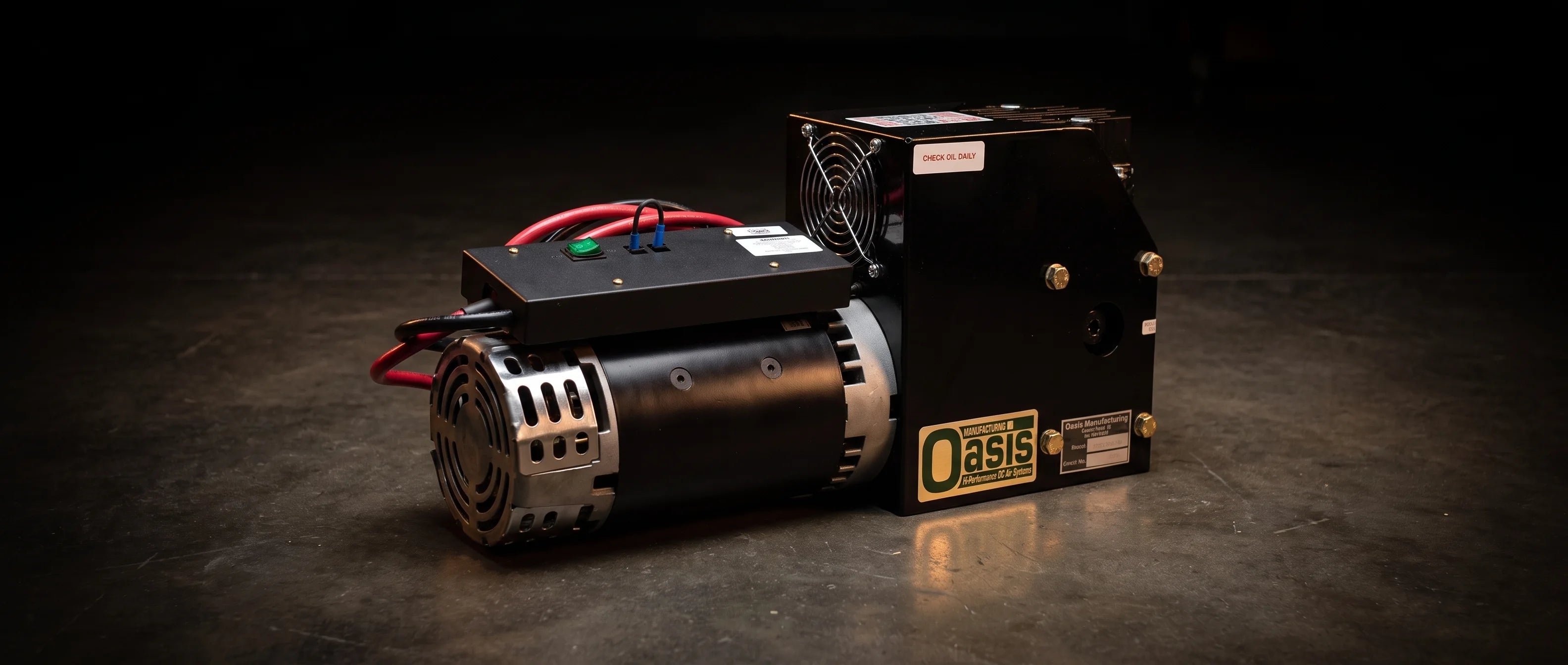 The Oasis XD4000 on a dark workshop floor, warm light picking out the motor barrel, the cooling fan grille and the brass bolts